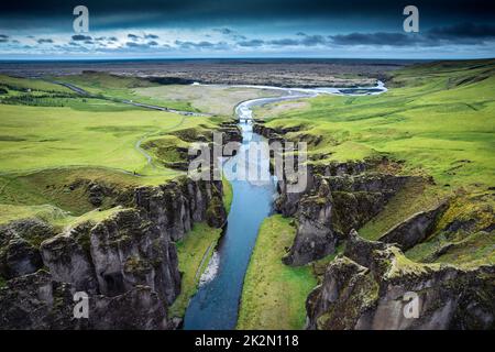 Luftaufnahme wunderschöne, zerklüftete Moos Fjadrargjufur Schlucht mit Fjadra, die im Sommer im Südosten Islands durchfließt Stockfoto