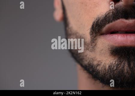 Der abgeschnittene Blick auf den Mund eines bärtigen Mannes Stockfoto