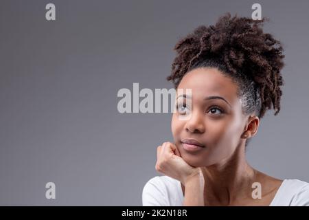 Eine seriöse, junge Schwarze, die tief im Kopf sitzt Stockfoto