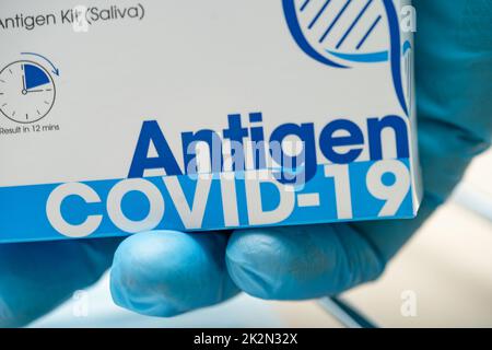 Arzt im PSA-Anzug mit Speichelantigen-Testkit zur Kontrolle des Covid-19-Coronavirus im Krankenhaus. Stockfoto