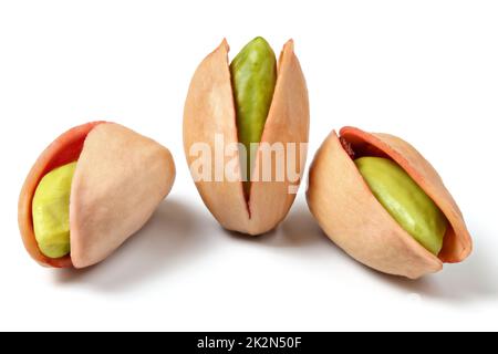 Drei Türkischen Roten Pistazien (antep Fistigi) geschälten grünen Nüsse unter Shell sichtbar, auf weißem Hintergrund. Stockfoto