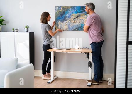 Glückliches Paar, Das Gemälde Hängt. Wanddekoration Stockfoto