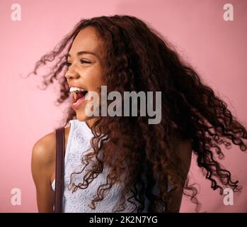 Nichts wird mich heute zu Boden bringen. Studioaufnahme einer schönen jungen Frau, die vor einem rosa Hintergrund posiert. Stockfoto