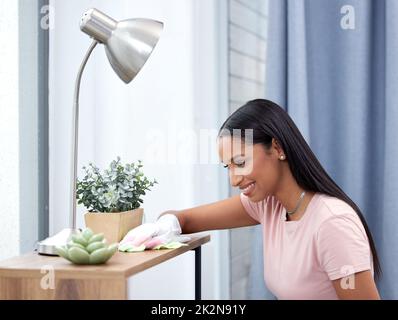 Dieses Haus ist sauber genug, um gesund zu sein. Aufnahme einer jungen Frau, die zu Hause ihre Theke abschrubbt. Stockfoto