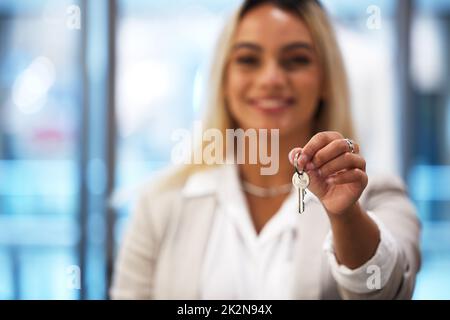 Der erste Tag des restlichen Lebens. Aufnahme einer jungen Frau, die die Schlüssel zu ihrem Bekleidungsgeschäft hält. Stockfoto