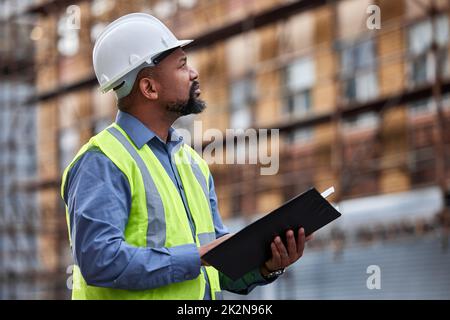 Achten Sie immer auf die Regeln. Aufnahme eines Auftragnehmers, der auf einer Baustelle Papierkram ausfüllt. Stockfoto