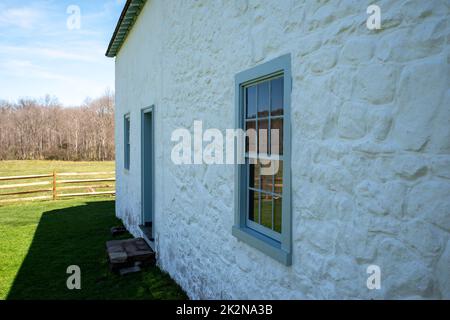 Seitenansicht eines weißen, kolonialen amerikanischen Steinhauses in ländlicher Landschaft Stockfoto