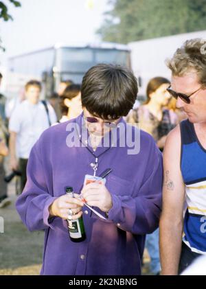 NOEL GALLAGHER ; Autogramm für einen Fan, Backstage bei Einem lazy Sunday Afternoon in Finsbury Park, London, UK ; 21. August 1996 ; Credit : Mel Longhurst / Performing Arts Images ; www.performingartsimages.com Stockfoto