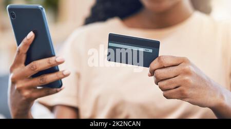 Schwarze Frau mit Telefon verwendet Kreditkarte für digitale, Online-Shopping und E-Commerce-Waren zu kaufen. Die Web-Sicherheitstechnologie macht das Bezahlen von Rechnungen mit Stockfoto