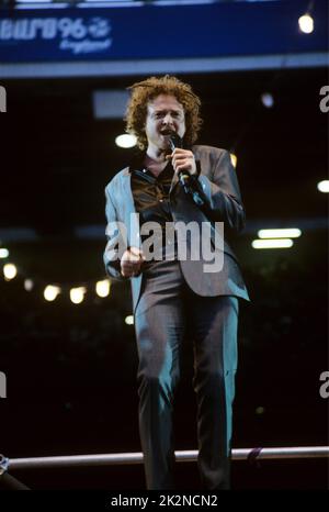 EINFACH ROT ; Mick Hucknall (Gesang) ; live im Old Trafford Stadium, Manchester, UK ; 29. Juni 1996 ; Credit : Mel Longhurst / Performing Arts Images ; www.performingartsimages.com Stockfoto