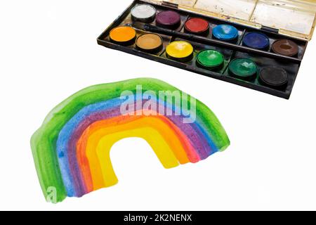 Kind zeichnet einen Regenbogen mit Farben. Stockfoto