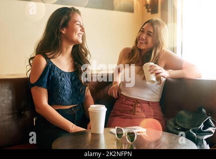 Holt ihre beste Freundin ein. Eine kurze Aufnahme von zwei attraktiven jungen Frauen, die in ihrem lokalen Café chillen. Stockfoto