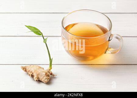 Tasse frisch gebrühten Kaffee, Glas gelb nass von Dampf, trockene Ingwer Wurzel mit Grün sprießen. Stockfoto