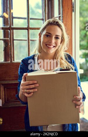 Ich bin so aufgeregt, einen neuen Start zu machen. Porträt einer jungen Frau, die beim Umzug eine Schachtel in der Hand hält. Stockfoto