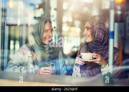 Kaffee schmeckt zusammen besser. Aufnahme von zwei Frauen, die sich bei einem Kaffee in einem Café unterhalten. Stockfoto