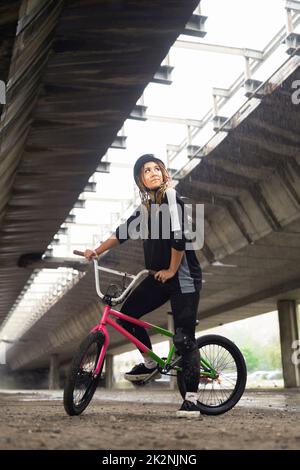 Junge Frau mit Helm und Freestyle-Bike Stockfoto