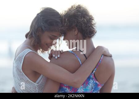 Du bist der einzige, mit dem ich zusammen sein möchte. Aufnahme von zwei jungen Frauen, die sich am Strand Vergnügen. Stockfoto