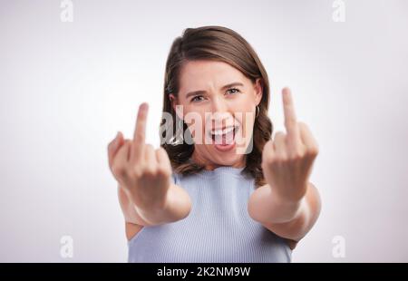 Nun, hier ist, was ich denke. Studioporträt einer jungen Frau mit Mittelfinger vor grauem Hintergrund. Stockfoto