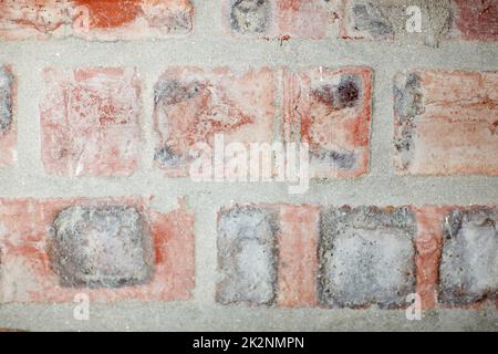 Stellen Sie sicher, dass Ihre Wände fest sind. Abgeschnittene Aufnahme einer verwitterten Backsteinwand. Stockfoto