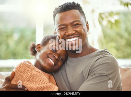 Jedes Kind braucht einen Vater. Aufnahme eines jungen Vaters, der seine Tochter umarmt. Stockfoto