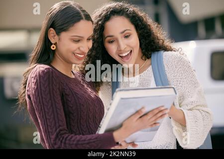 Du hast einen 100 Pass. Aufnahme von zwei jungen Frauen, die zusammen an der Hochschule studieren. Stockfoto