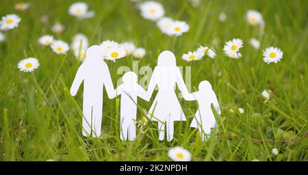 Auf einer Wiese steht Familienpapier ausgeschnitten, Eltern mit Tochter und Sohn, Umweltkonzept, Frühjahr- und Sommersaison Stockfoto