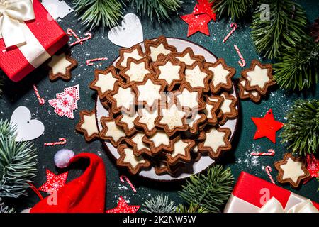 Weihnachtsstern Zucker glasierte Kekse, traditionelle Xmas dunkle und weiße Schokolade Lebkuchenkekse mit Feiertagsdekoration, Geschenke, Weihnachtsbaum-BH Stockfoto