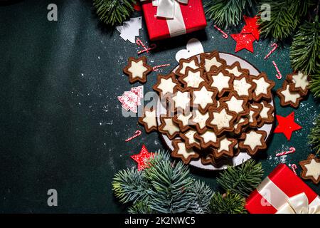 Weihnachtsstern Zucker glasierte Kekse, traditionelle Xmas dunkle und weiße Schokolade Lebkuchenkekse mit Feiertagsdekoration, Geschenke, Weihnachtsbaum-BH Stockfoto