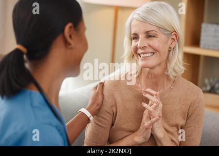 Dich gesund zu sehen, macht mich so glücklich. Aufnahme eines Arztes, der sich zu Hause mit einer älteren Frau beraten hat. Stockfoto