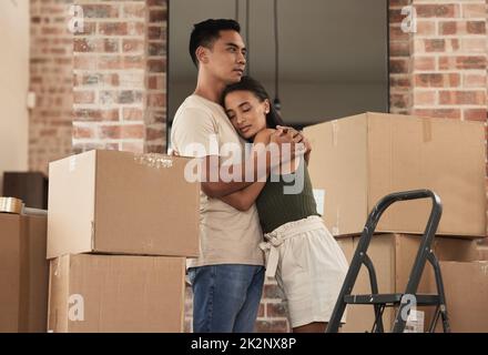 Lasst uns zusammen bleiben. Aufnahme eines jungen Paares, das sich in ihr neues Zuhause umarmt. Stockfoto