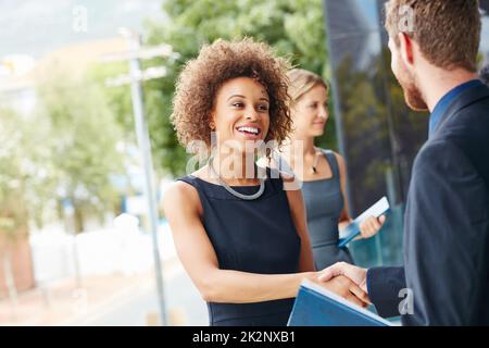 Geh nach draußen und treffe neue Leute. Aufnahme einer Geschäftsfrau und eines Geschäftsmannes, die sich im Freien die Hände schüttelten. Stockfoto