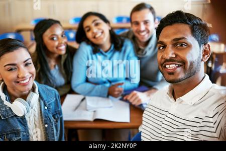 Das College ist super. Beschnittenes Porträt einer Gruppe junger Studenten, die in der Klasse sitzen. Stockfoto