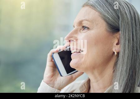 Klar, ich bin im obersten Stockwerk. Eine kurze Aufnahme einer attraktiven, reifen Geschäftsfrau, die auf dem Balkon ihres Büros telefonische Anrufe macht. Stockfoto