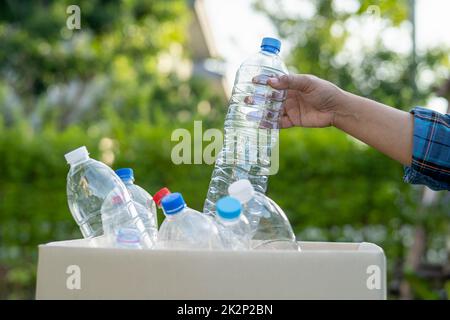 Asiatische Frau Freiwillige tragen Wasser Plastikflaschen in Müllkiste Müll im Park, recyceln Abfall Umwelt Ökologie Konzept. Stockfoto