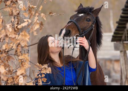 Nahaufnahme eines Pferdes und eines schönen Mädchens mit slawischem Aussehen Stockfoto