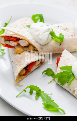 Tortilla gefüllt mit Hühnerfleisch, rotem Pfeffer und Bohnen Stockfoto