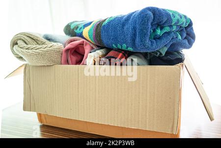 Spendenbox mit gebrauchter Kleidung zu Hause, um die Hilfe für arme Menschen in der Welt zu unterstützen. Stockfoto