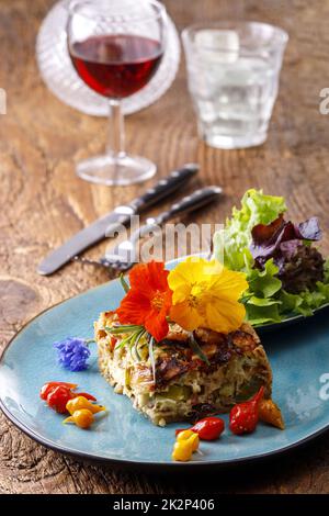 Stück französische Quiche mit Salat Stockfoto