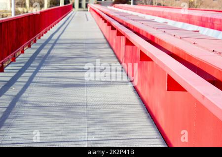 Detail der metallisch roten Brücke über der Eisenbahn Stockfoto