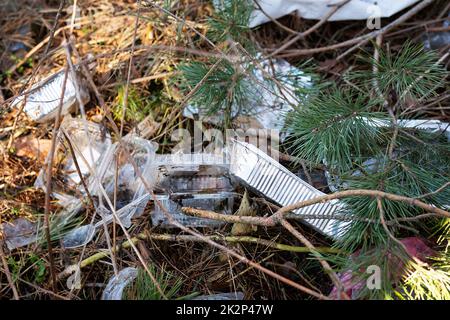 Viele Einwegbehälter aus Kunststoff, Abfall liegt in einer dicken Schicht in der Wildnis und zieht Vögel und Nagetiere an. Umweltverschmutzung. Stockfoto