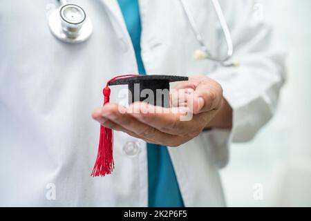 Asiatische Arzt Studie lernen mit Abschluss GAP Hut in Krankenhausstation, clever hell Genie Bildung Medizin Konzept. Stockfoto