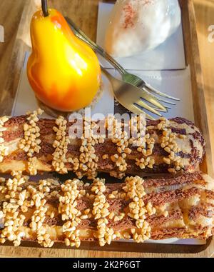 Köstliche frische Kuchen und Dessert in Form einer Birne auf einem Holzteller mit Gabeln, Süßwaren Stockfoto