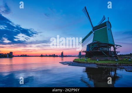 Windmühlen an der berühmten Touristenattraktion Zaanse Schans in Holland mit dramatischem Himmel. Zaandam, Niederlande Stockfoto