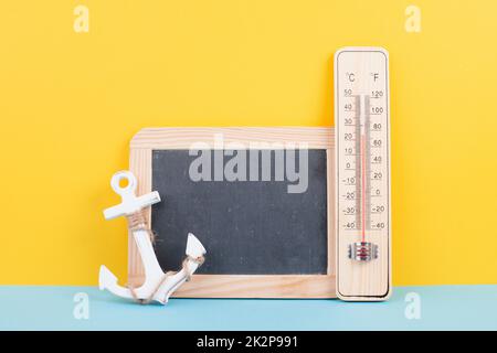 Leere Tafel mit Thermometer und Anker, Hintergrund im Urlaub, Sommerurlaub, heißes Wetter, Umweltproblem Stockfoto