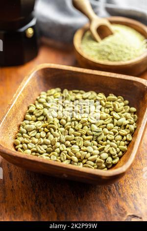 Nicht geröstete grüne Kaffeebohnen in einer Holzschüssel. Stockfoto