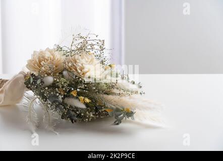 Strauß getrockneter Blumen auf einem weißen Tisch. Stockfoto