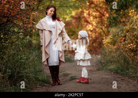 Bezaubernd schöne Mutter geht mit kleinen Tochter Mädchen Stockfoto