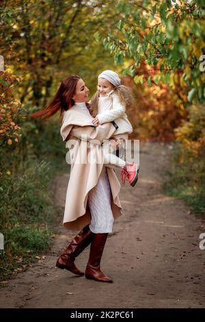 Bezaubernd schöne Mutter geht mit kleinen Tochter Mädchen Stockfoto