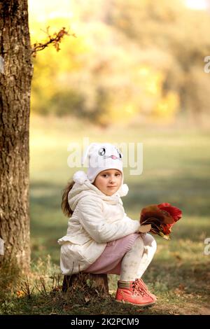 Baby Mädchen einen Strauß gelber Blätter auf Herbst Tag wählen Stockfoto