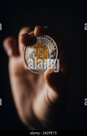 Silberne Bitcoin-Kryptowährung in einer Hand Stockfoto